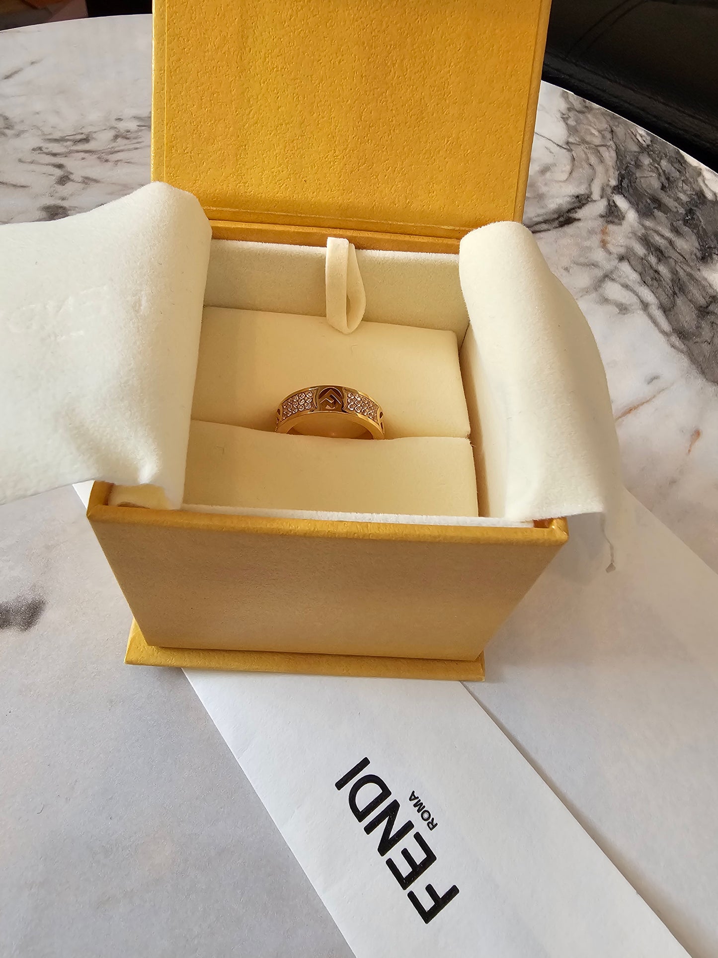 F- Fendi ring in golden with stones.