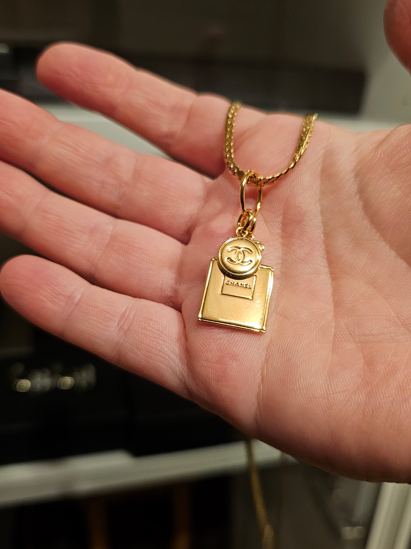 Chanel vedhæng + en guldbelagt kæde.