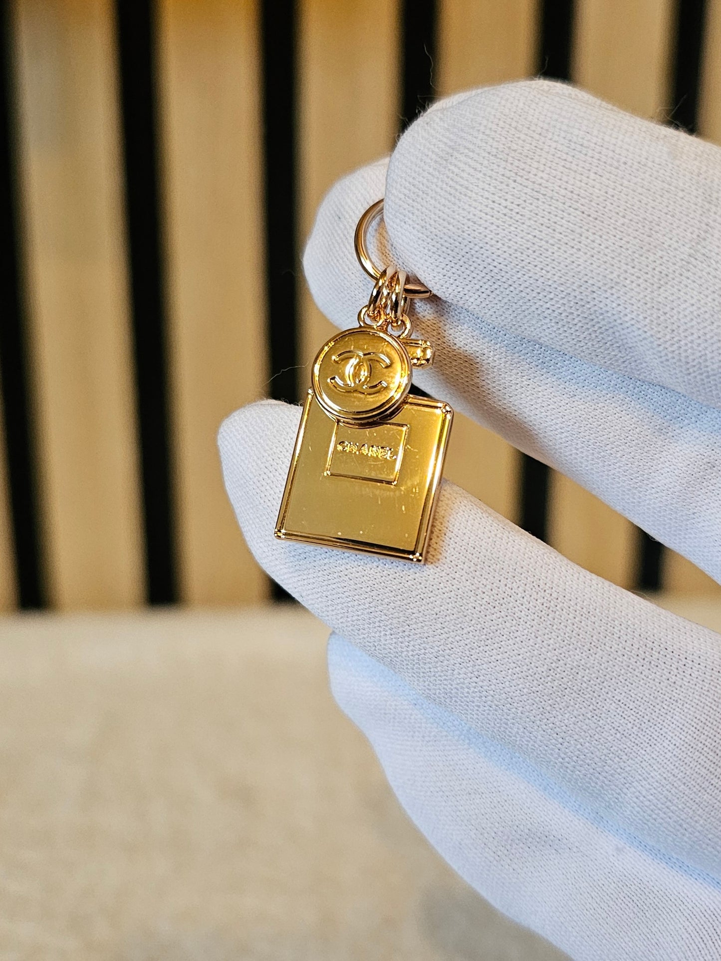 Chanel mini bag charm. Golden perfume bottle.