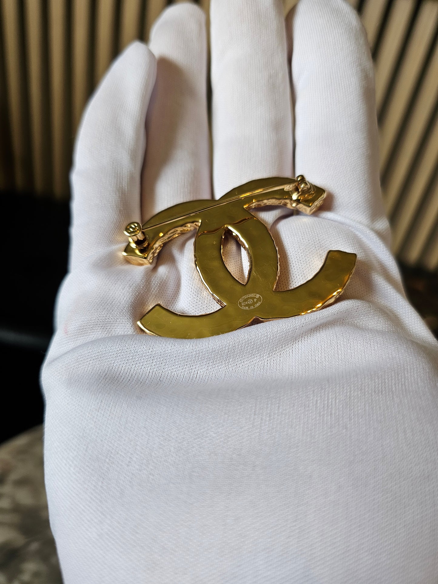 Chanel golden CC broche with black design.