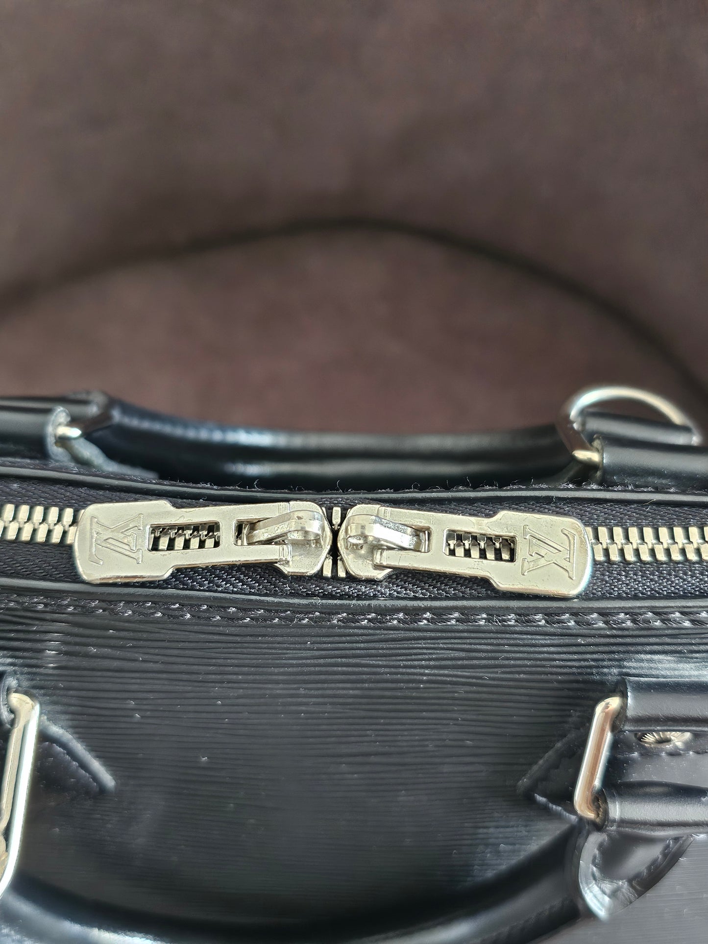 Louis Vuitton Alma PM with adjustable shoulder strap.