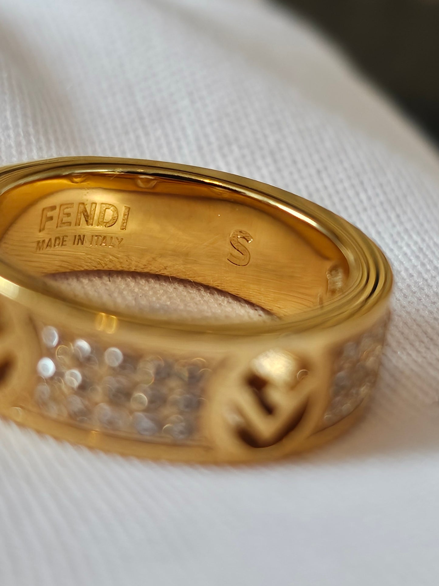 F- Fendi ring in golden with stones.