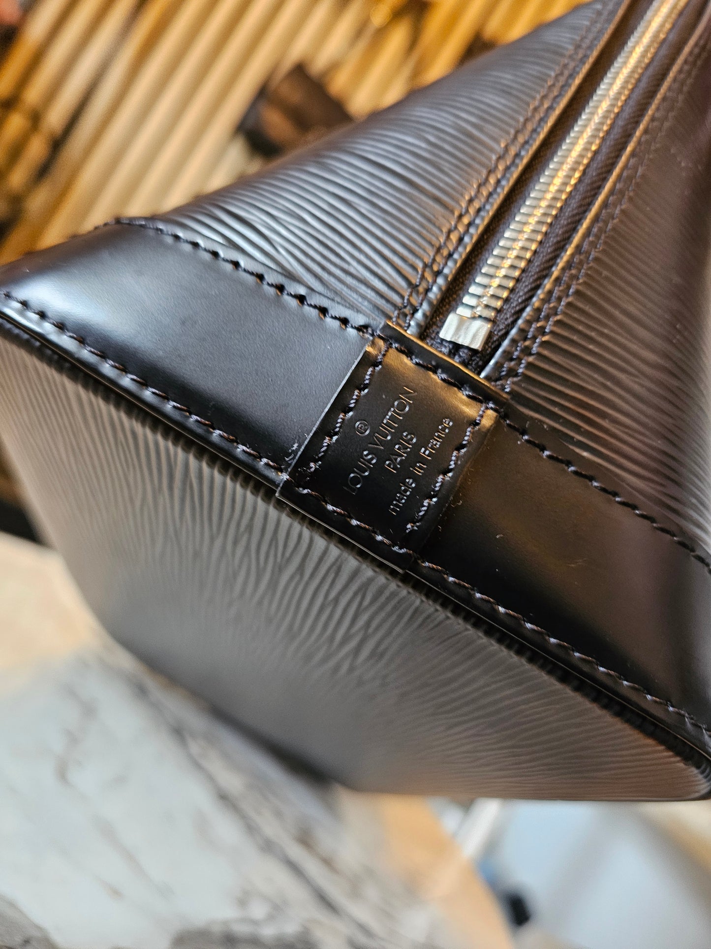 Louis Vuitton Alma PM with adjustable shoulder strap.