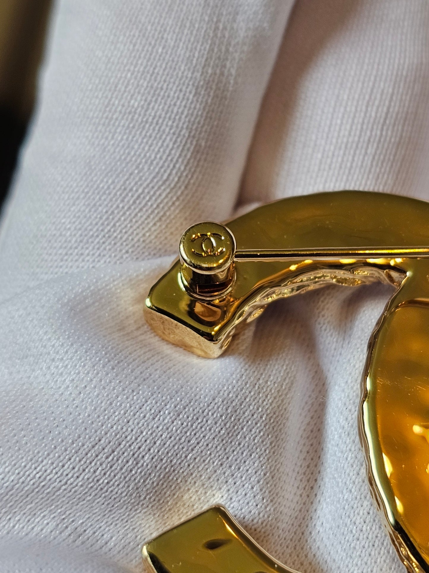 Chanel golden CC broche with black design.