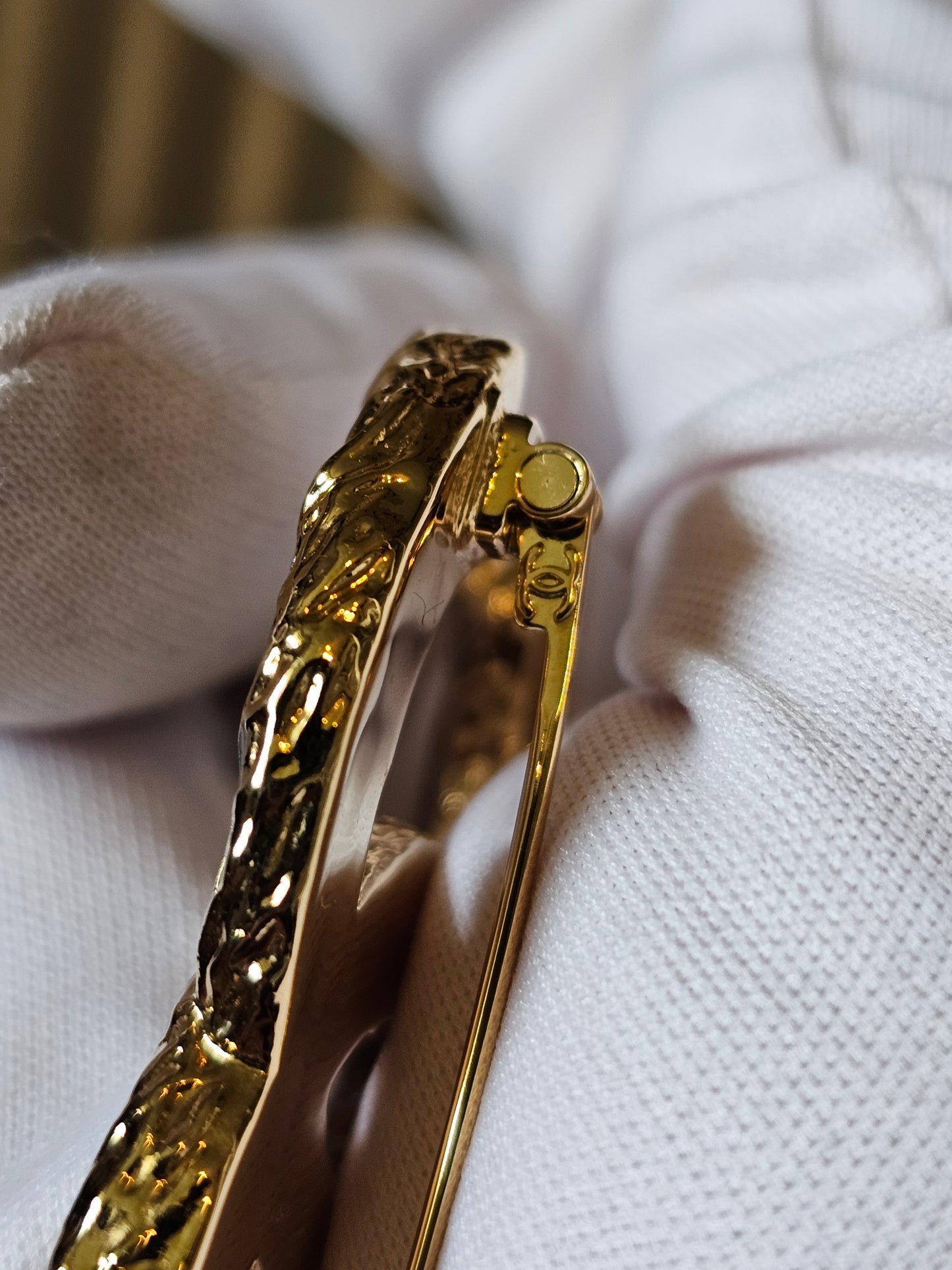 Chanel golden CC broche with black design.