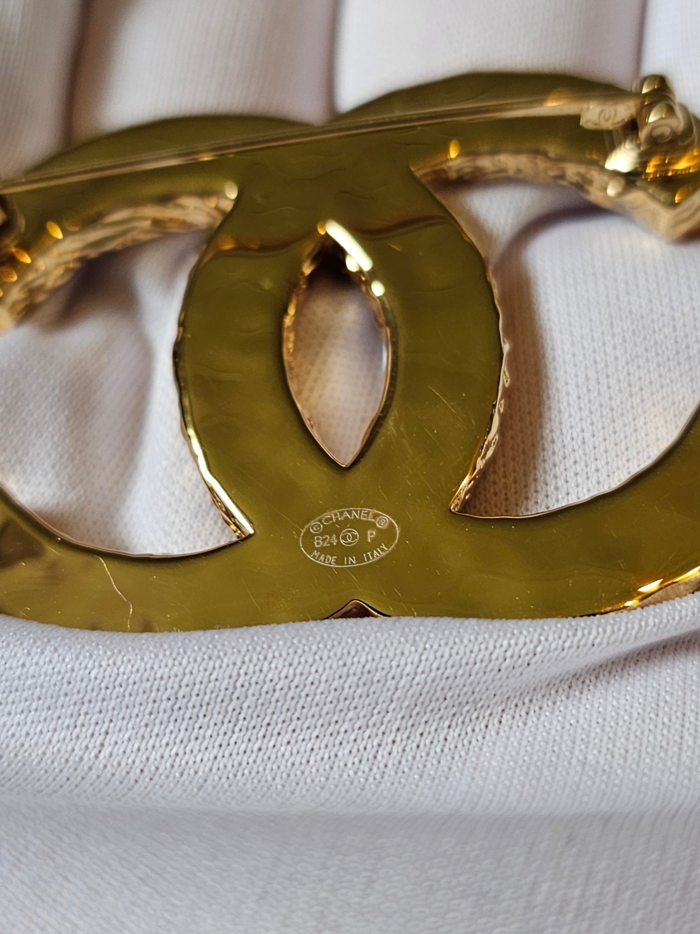 Chanel golden CC broche with black design.