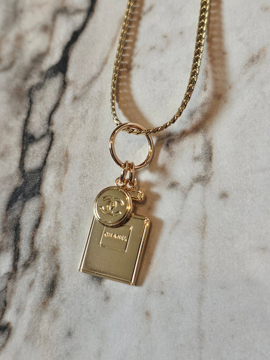 Chanel vedhæng + en guldbelagt kæde.