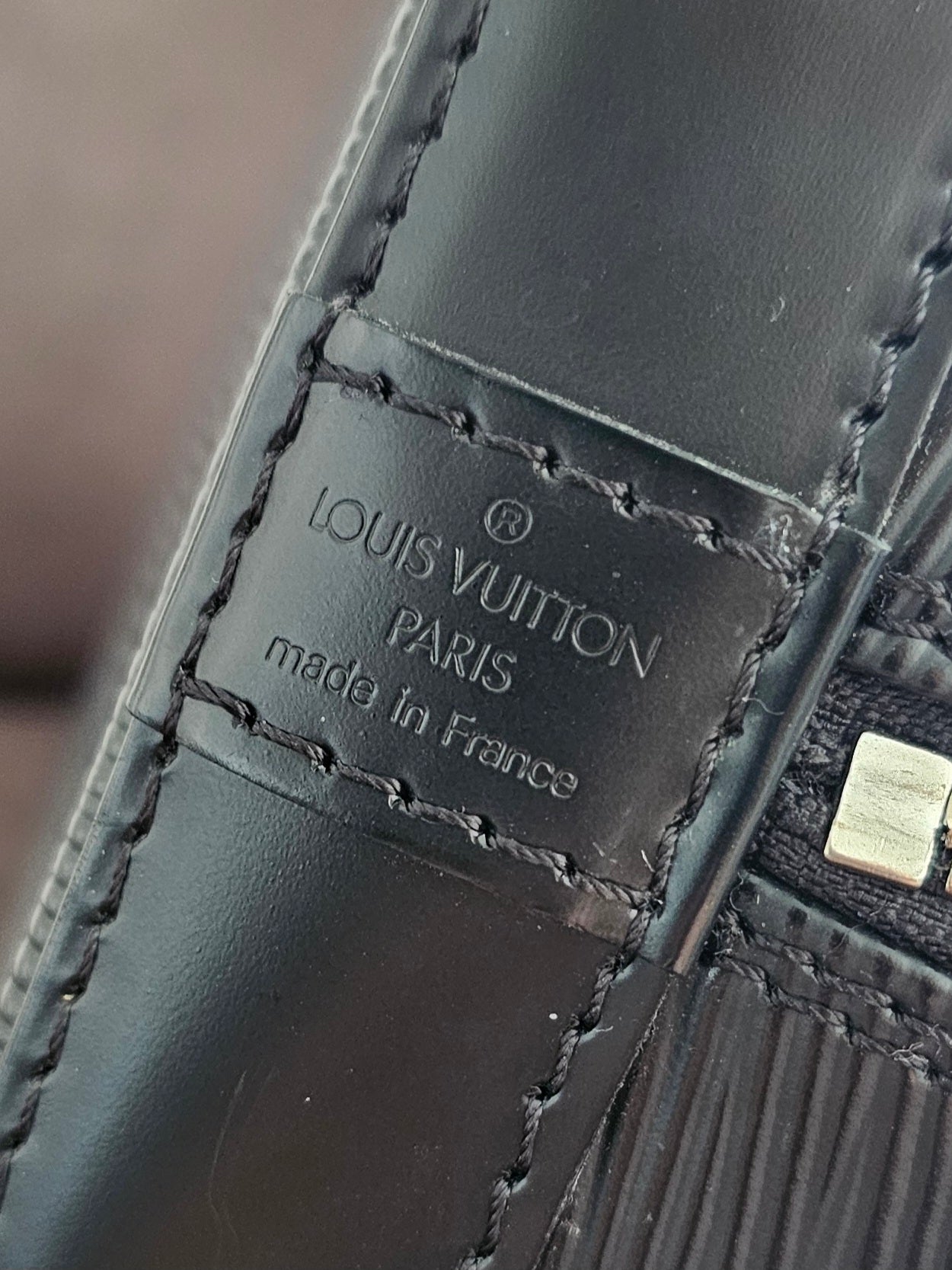 Louis Vuitton Alma PM with adjustable shoulder strap.