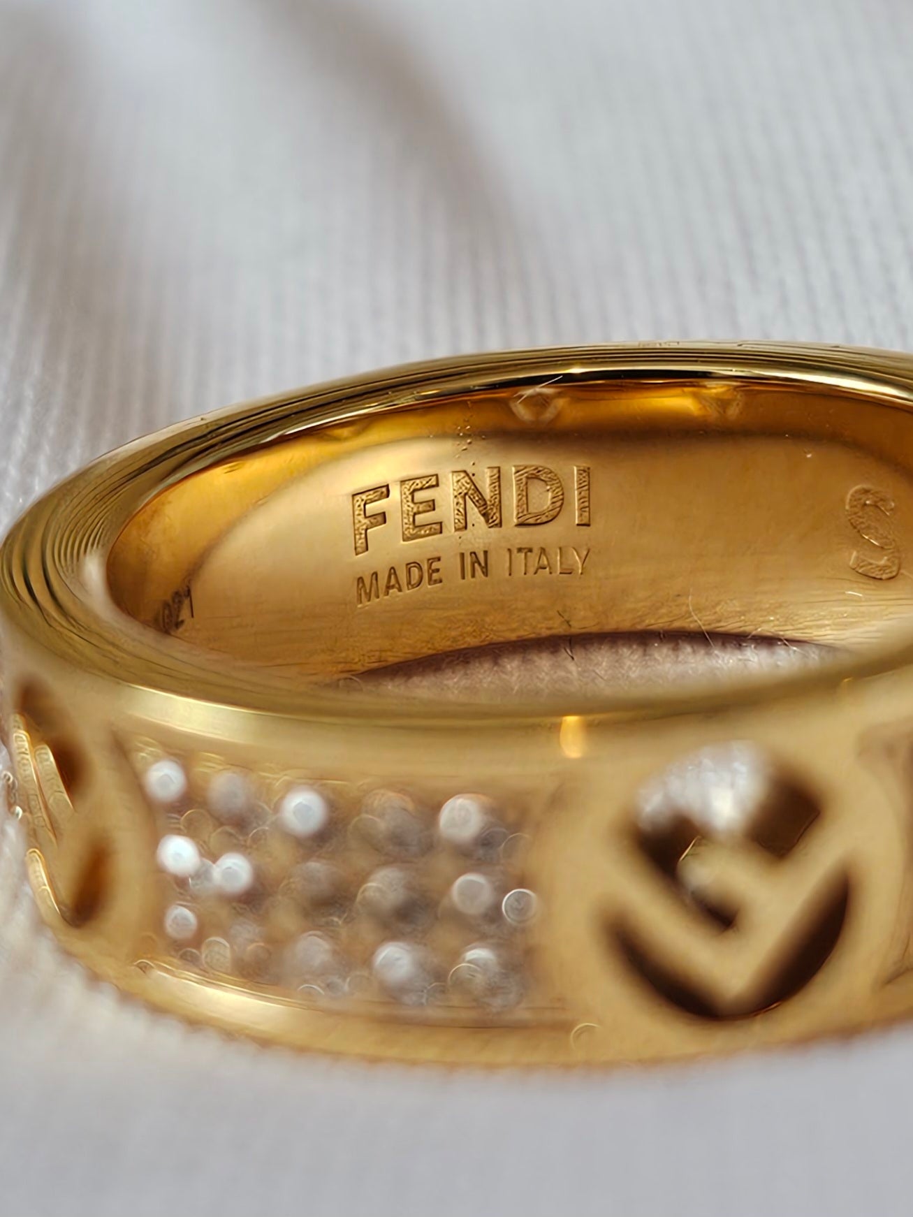 F- Fendi ring in golden with stones.