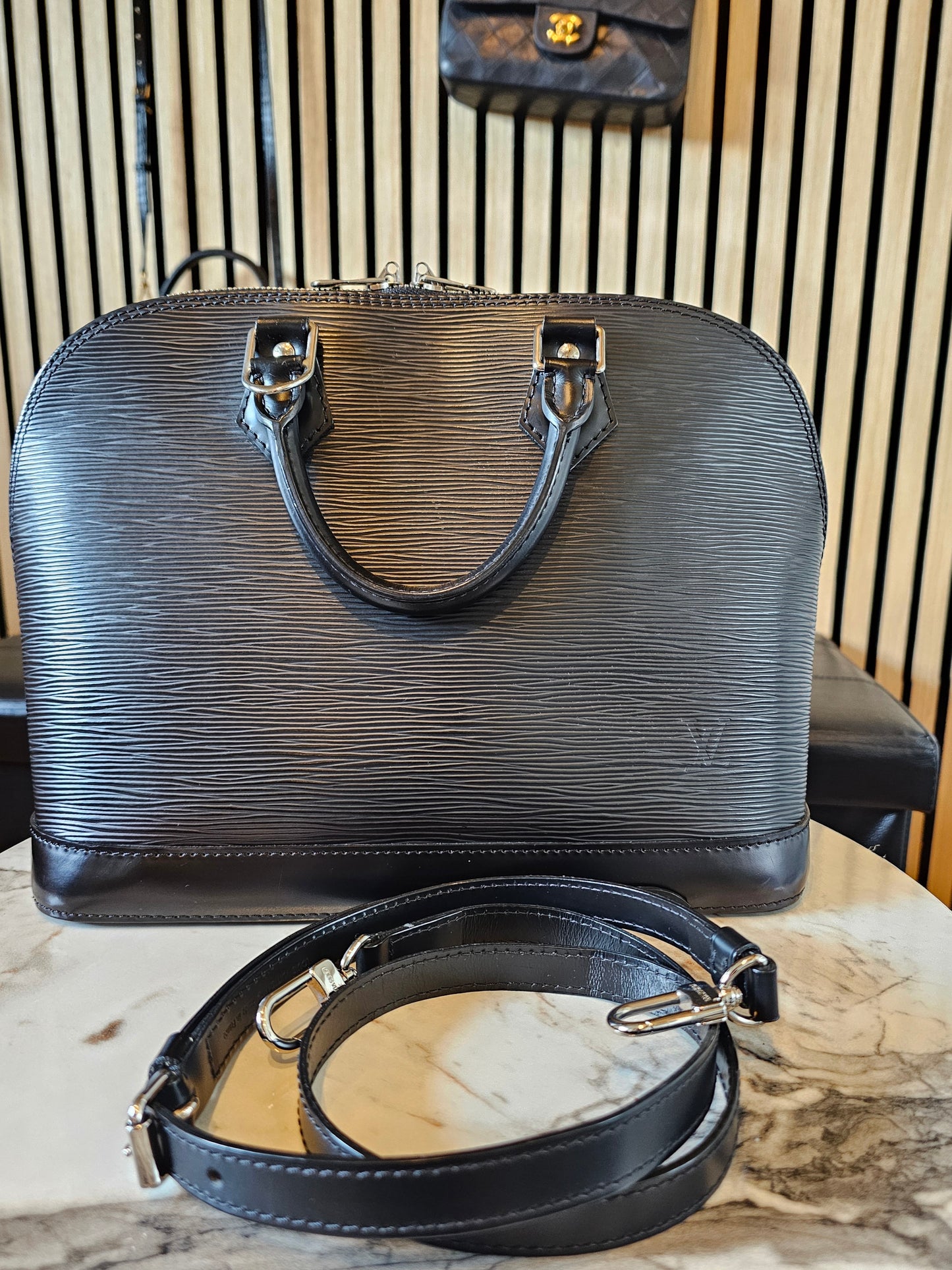 Louis Vuitton Alma PM with adjustable shoulder strap.