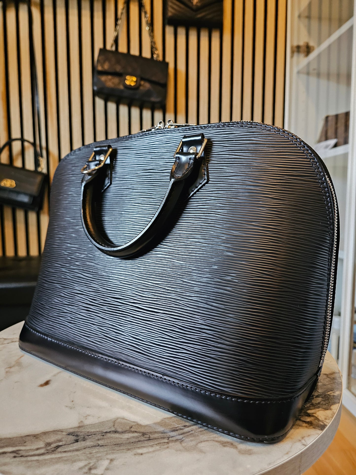 Louis Vuitton Alma PM with adjustable shoulder strap.