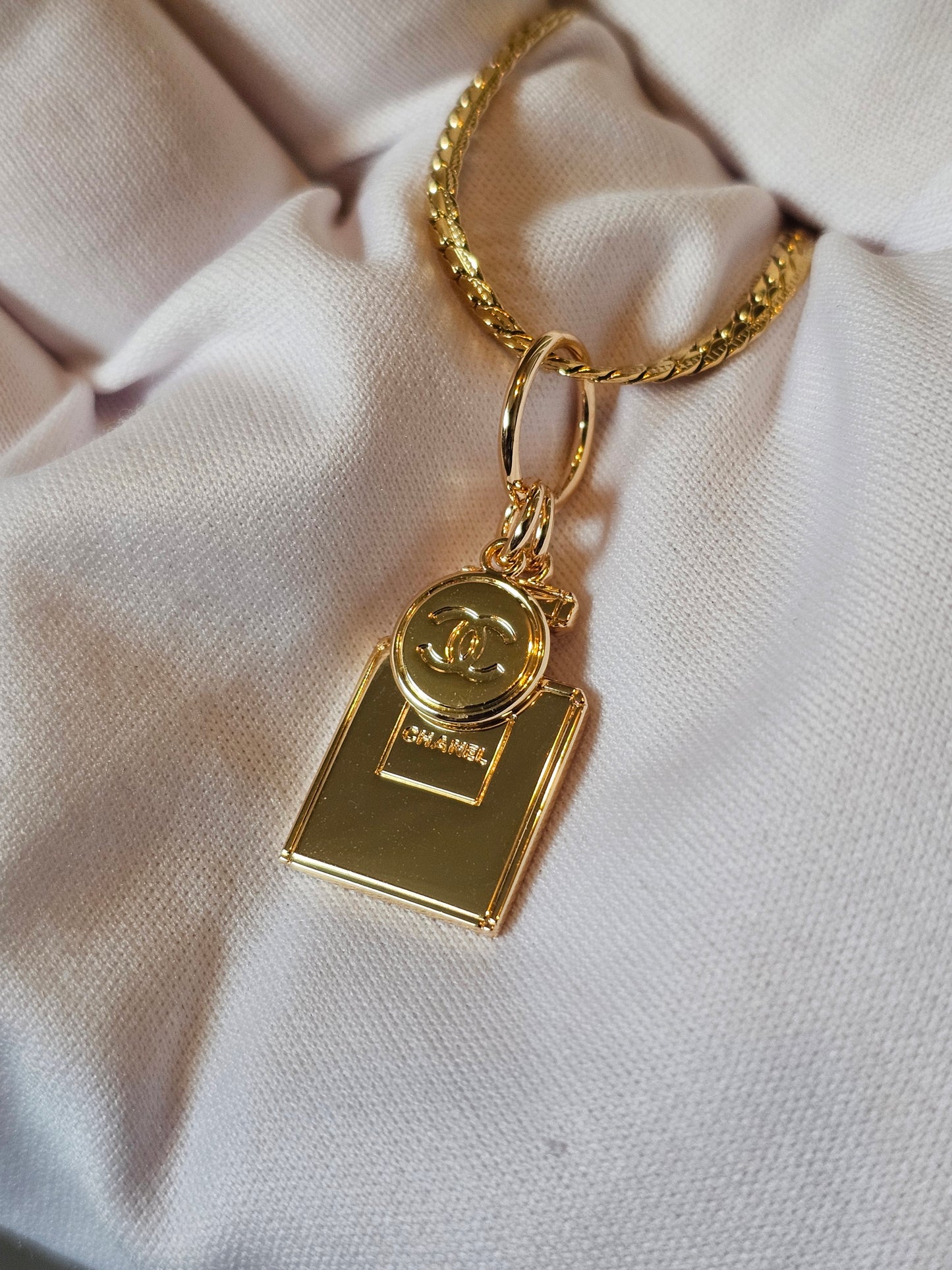 Chanel vedhæng + en guldbelagt kæde.