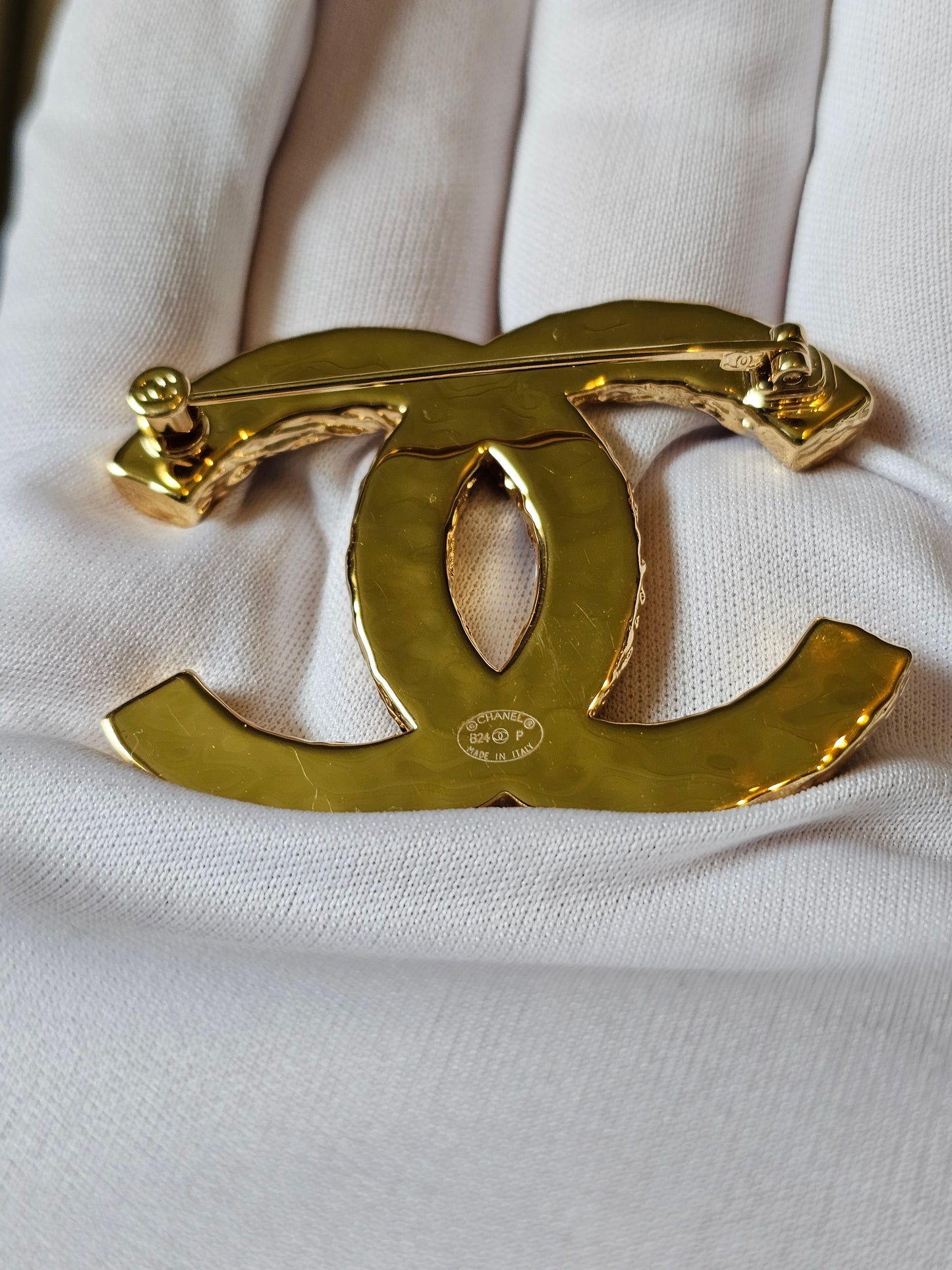 Chanel golden CC broche with black design.