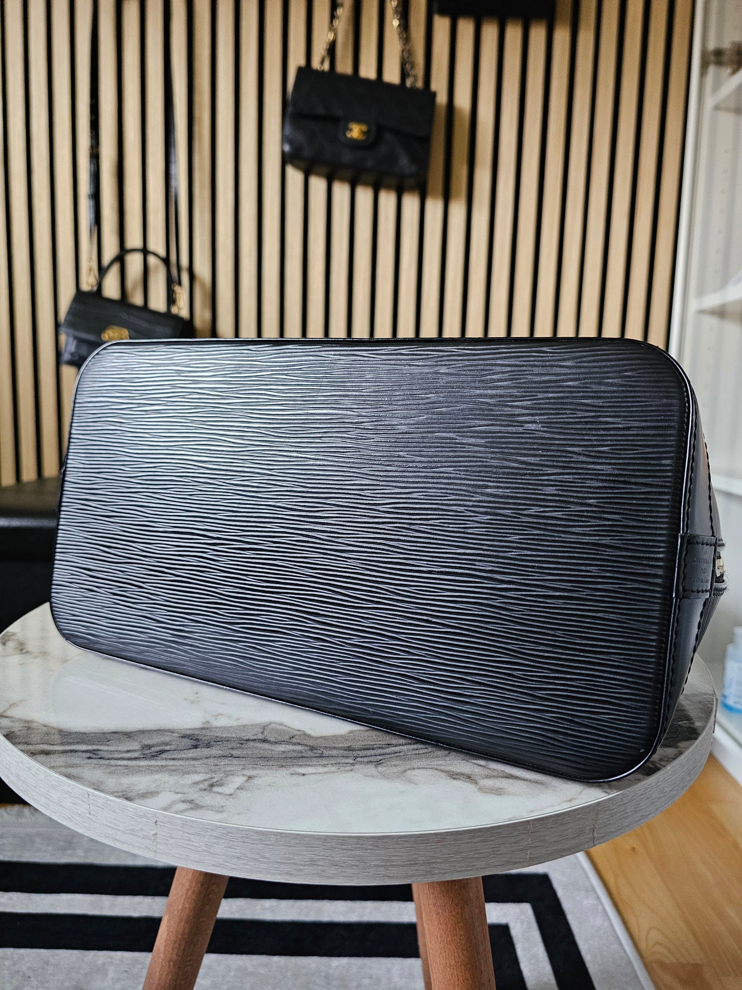 Louis Vuitton Alma PM with adjustable shoulder strap.