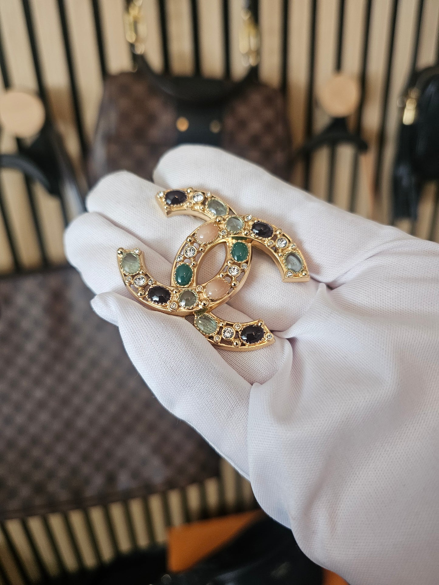 Chanel golden broche with multicolorwd stones.