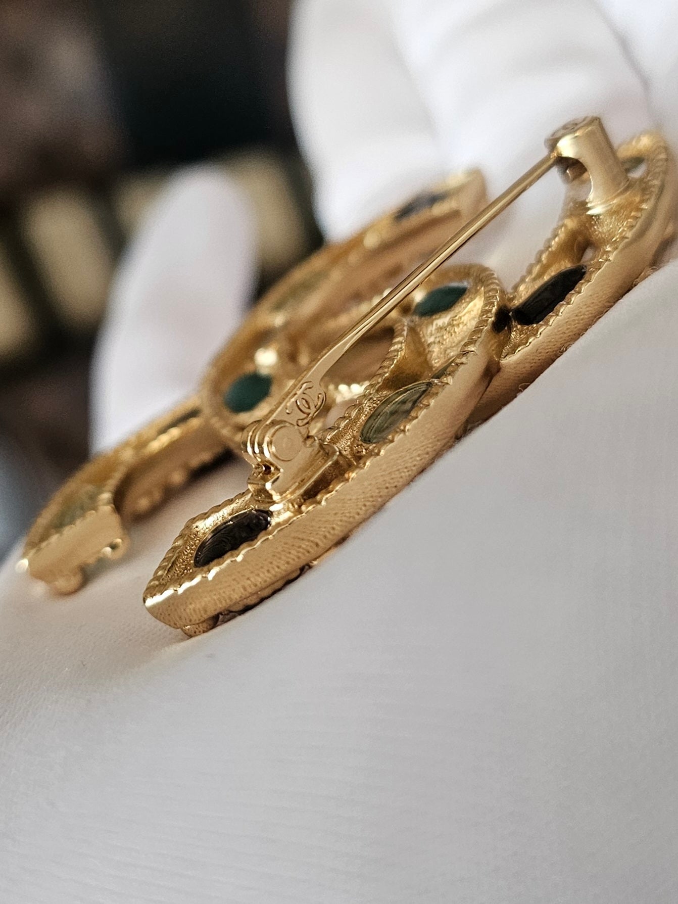 Chanel golden broche with multicolorwd stones.