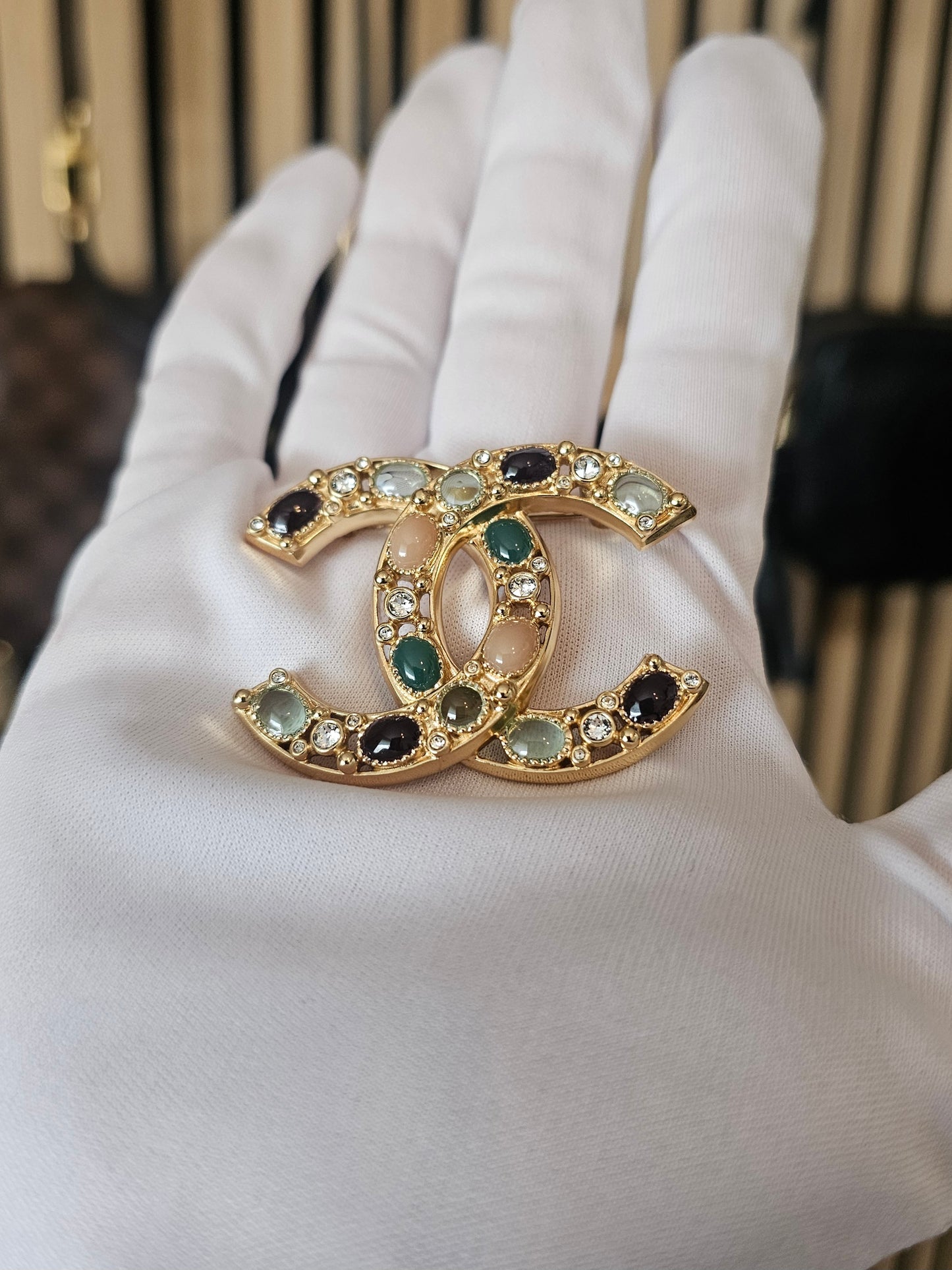 Chanel golden broche with multicolorwd stones.