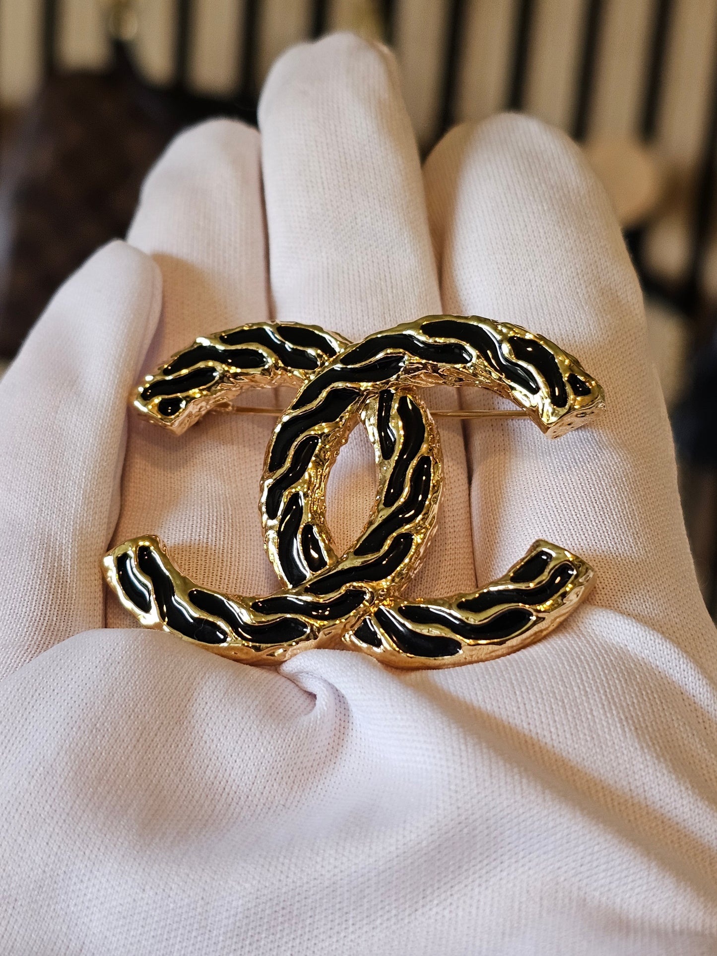 Chanel golden CC broche with black design.