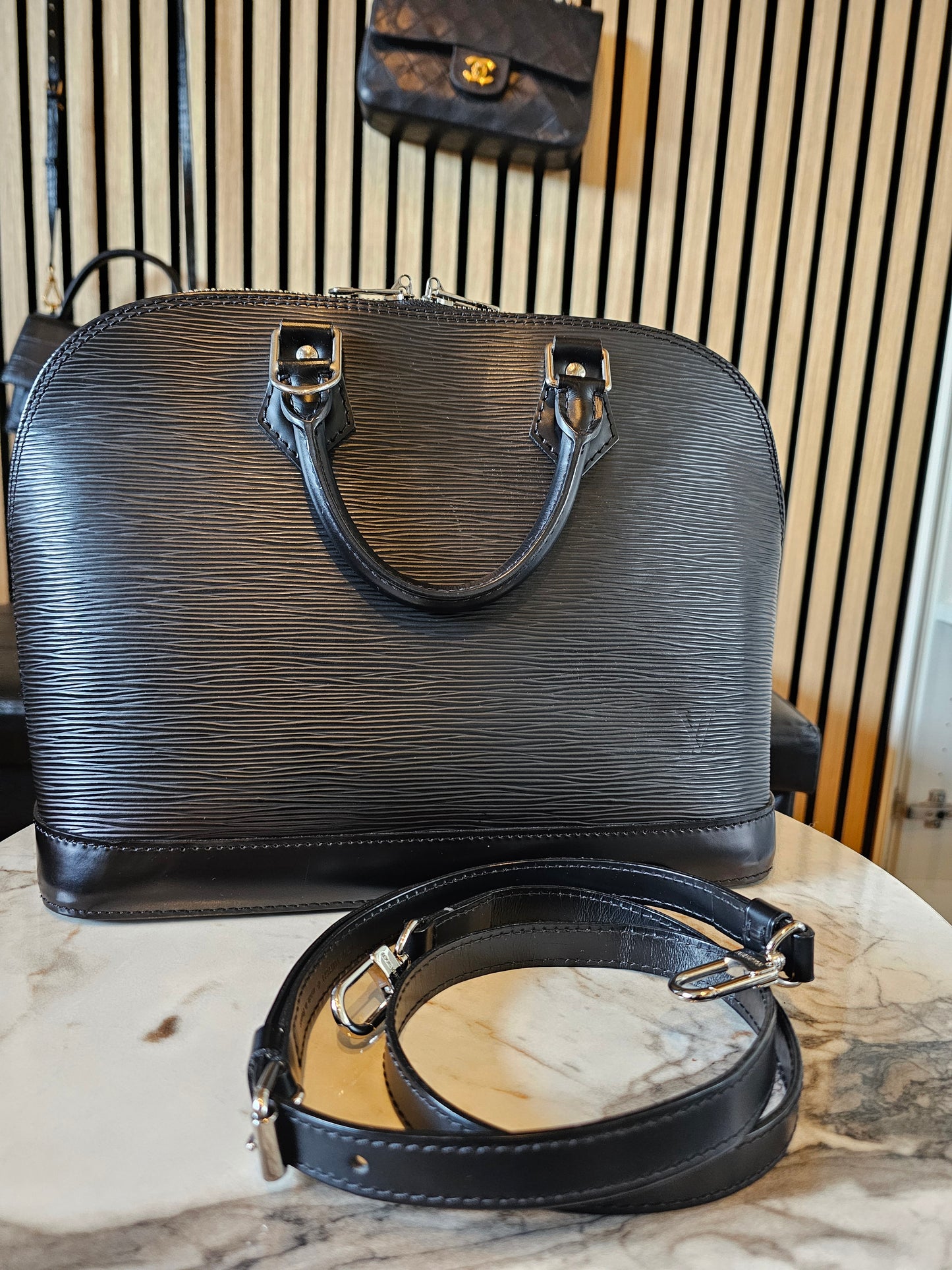 Louis Vuitton Alma PM with adjustable shoulder strap.