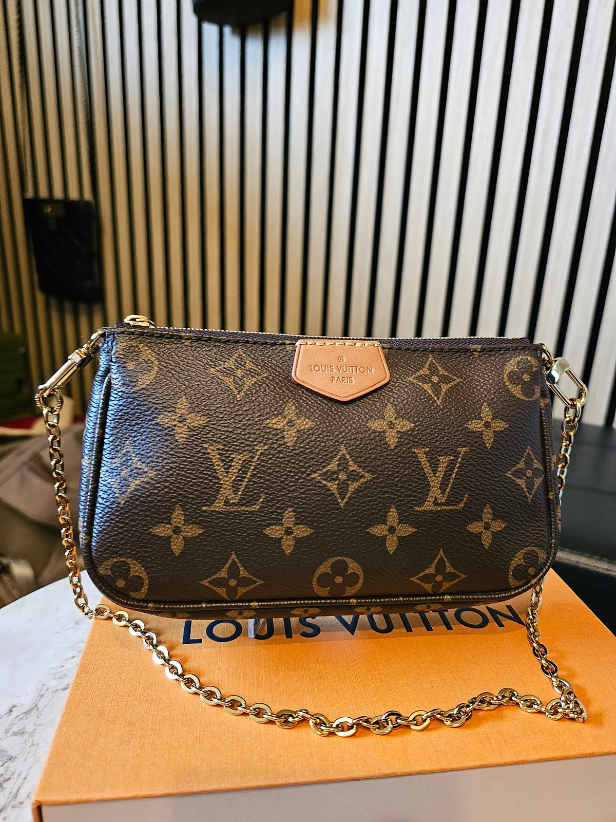 Louis Vuitton small pochette in monogram kanvas, with gold chain.
