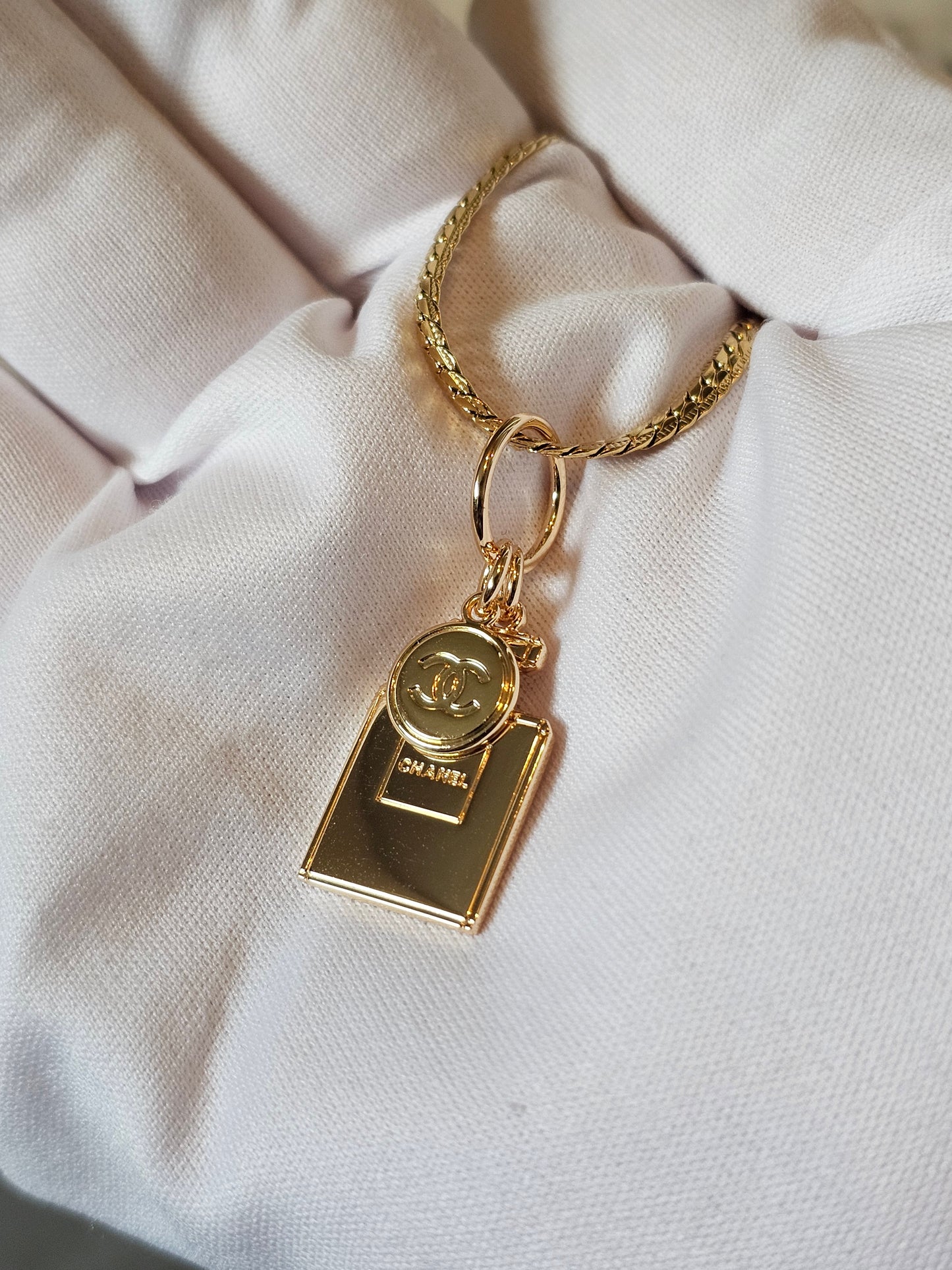 Chanel vedhæng + en guldbelagt kæde.