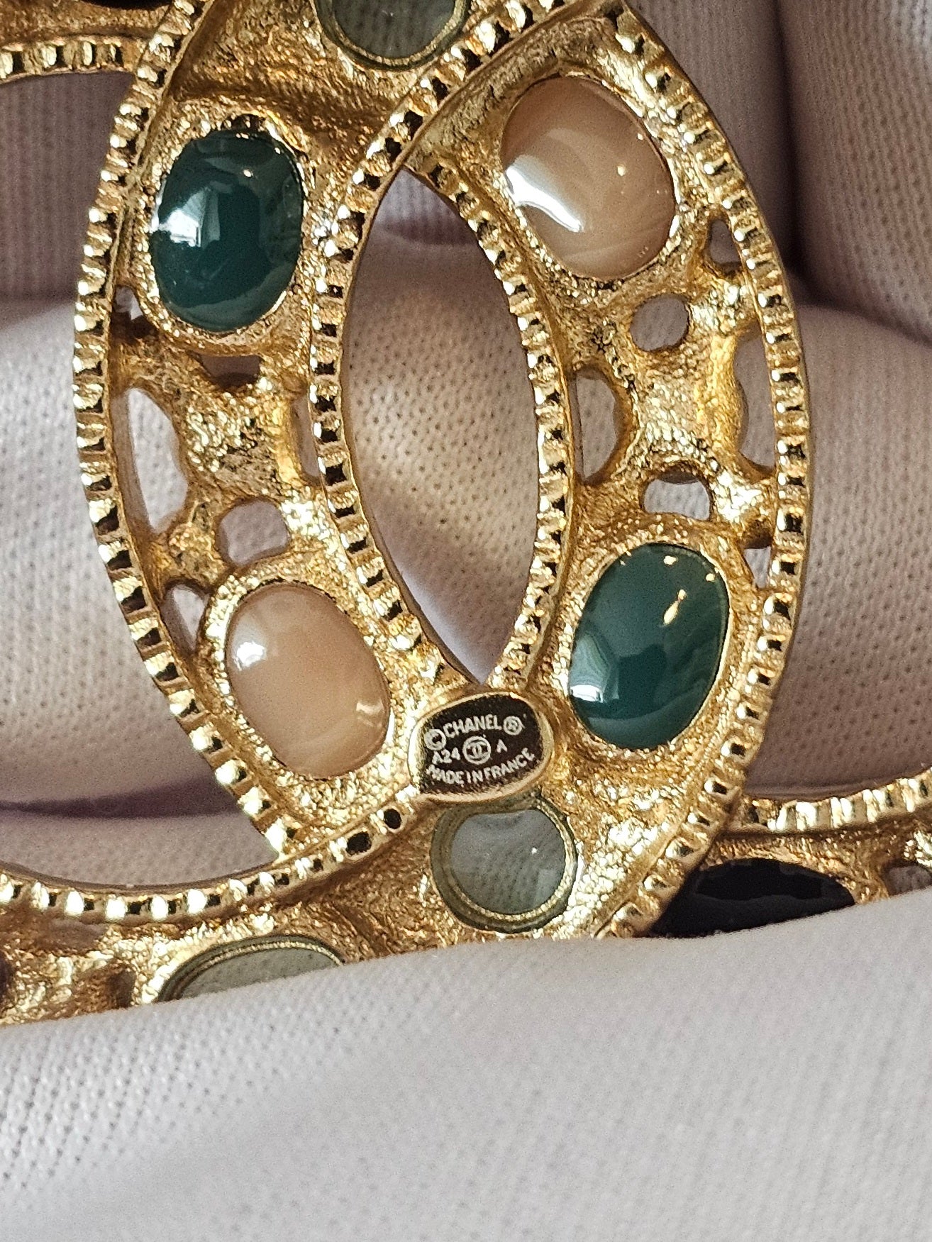 Chanel golden broche with multicolorwd stones.