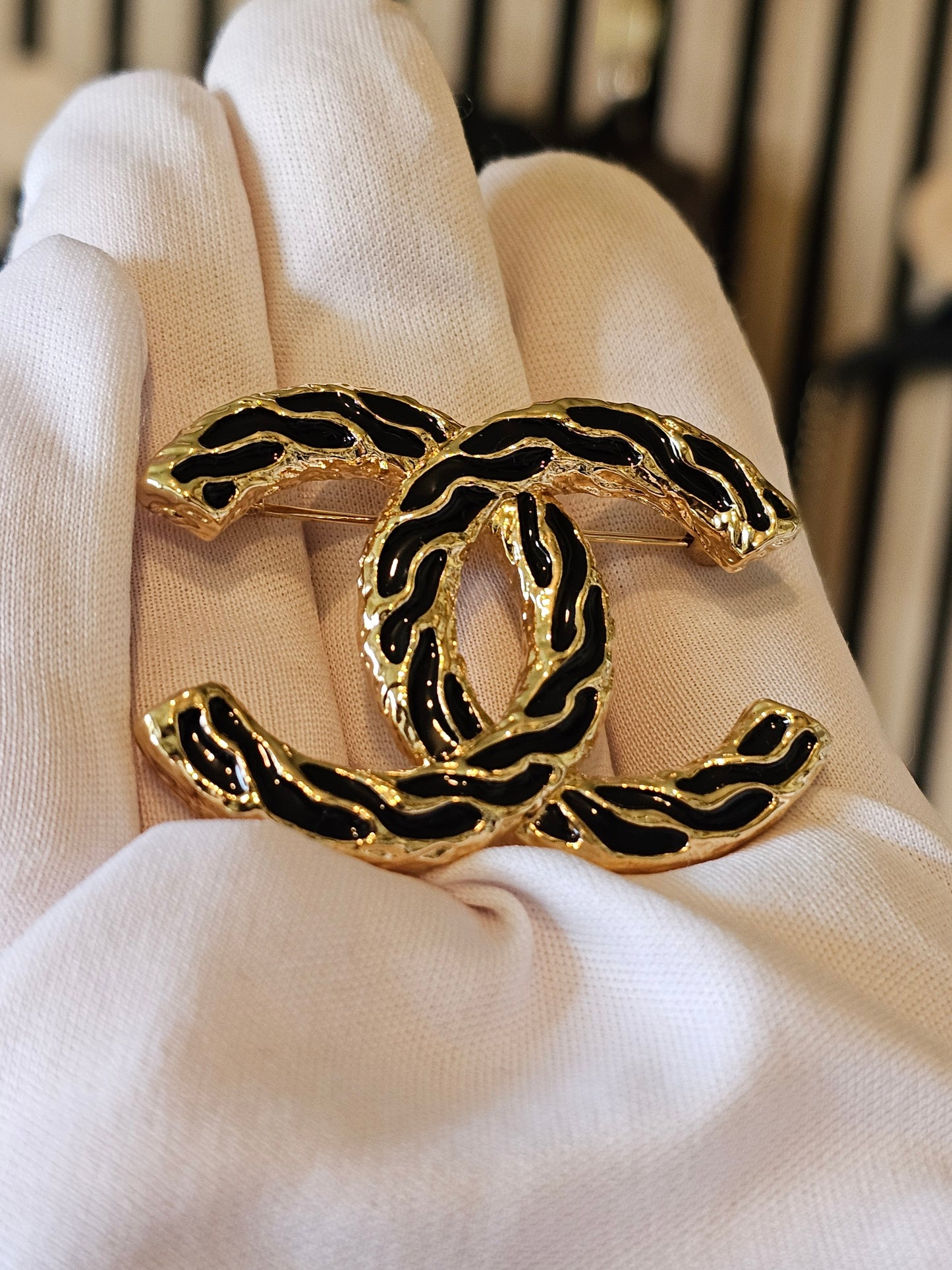 Chanel golden CC broche with black design.